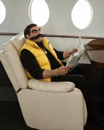 Enzo Puff leyendo el periódico en el sillón de un jet privado