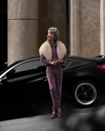 Yves junto a un auto negro de lujo
